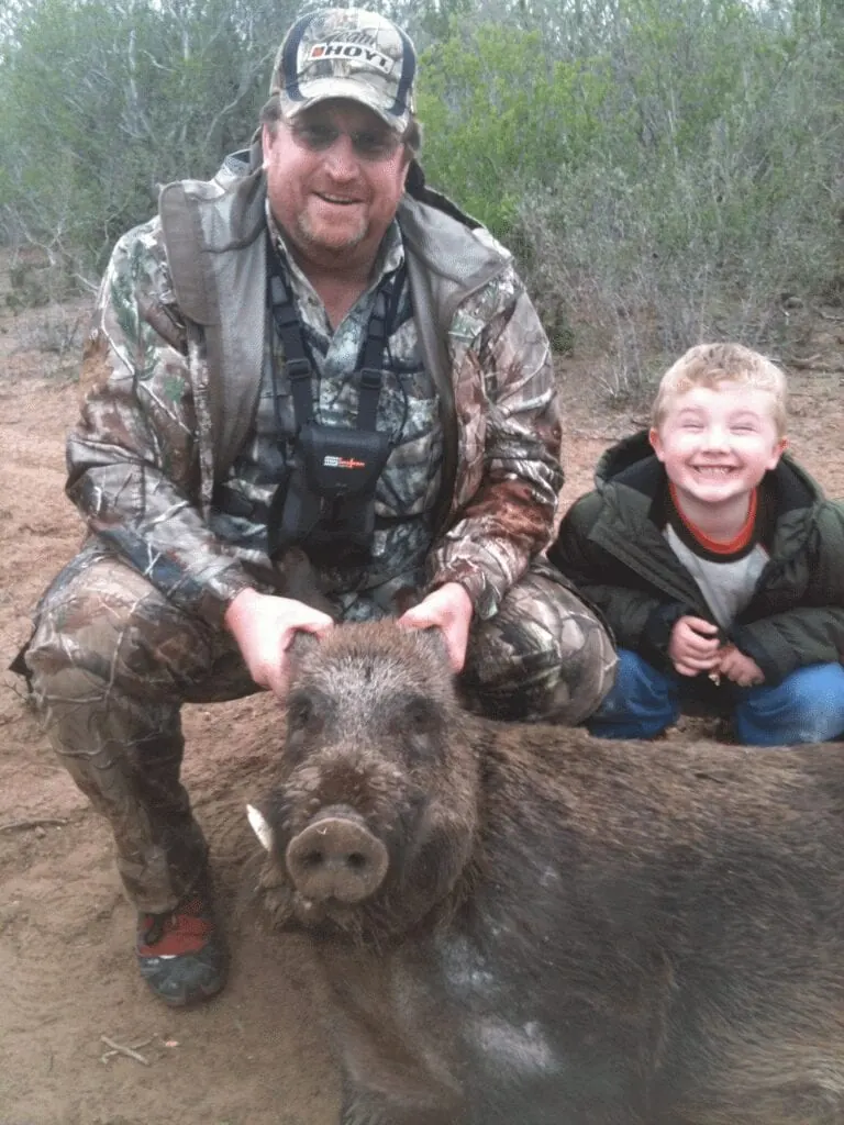Hunter and a young boy with a wild boar