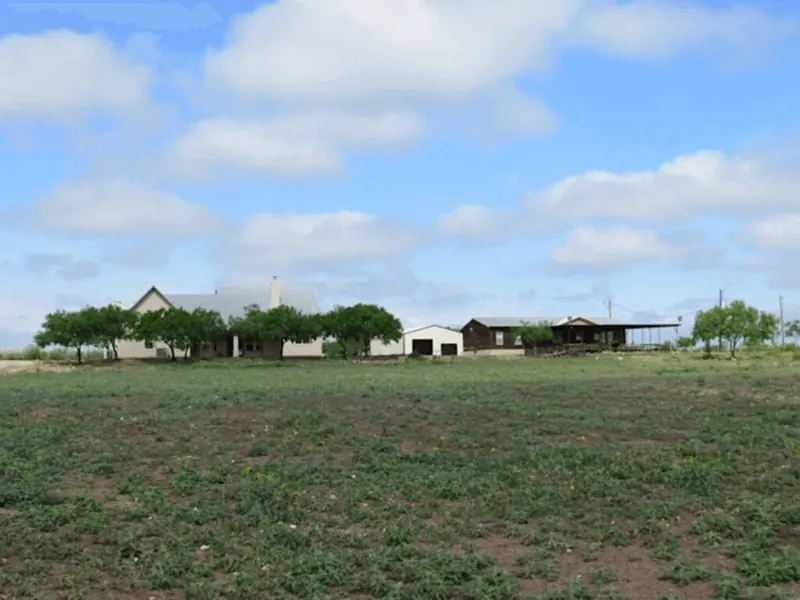 Ranch buildings beyond an open field at T14 Ranch