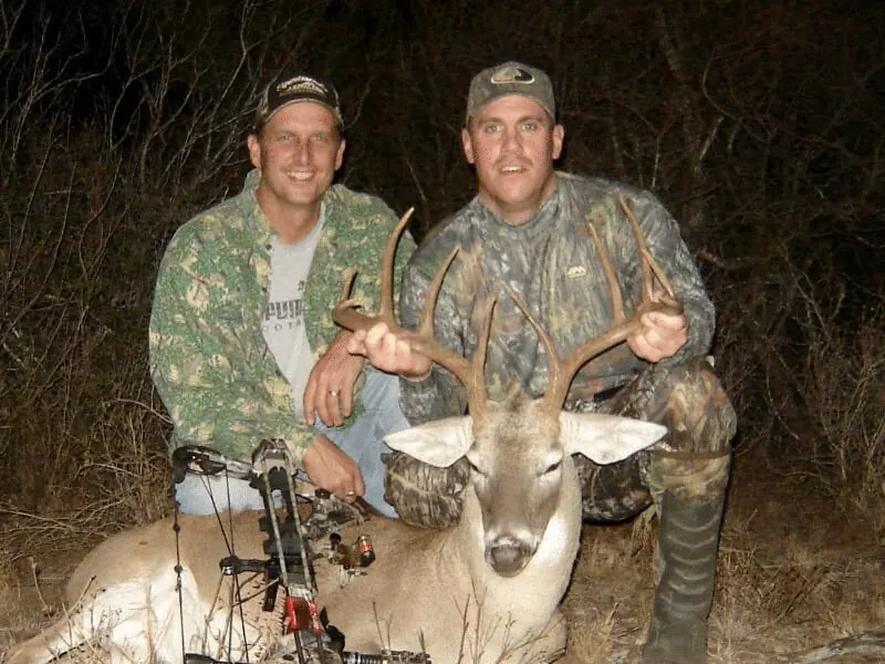 Two hunters with a white-tailed buck
